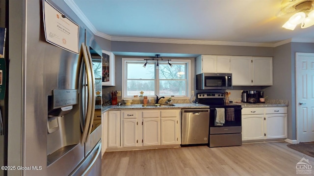 kitchen with light wood-style flooring, stainless steel appliances, crown molding, white cabinetry, and a sink