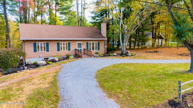 ranch-style house with driveway, a front lawn, a chimney, and fence