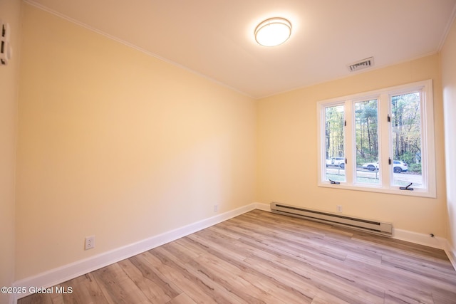 unfurnished room featuring visible vents, baseboards, baseboard heating, crown molding, and light wood-type flooring