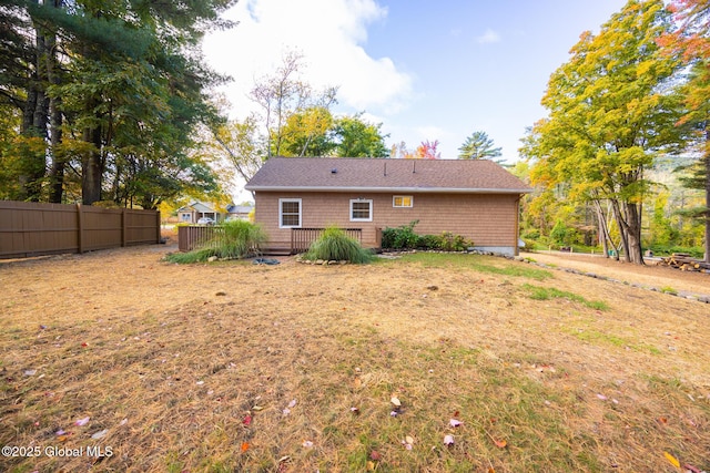 rear view of house with fence and a wooden deck