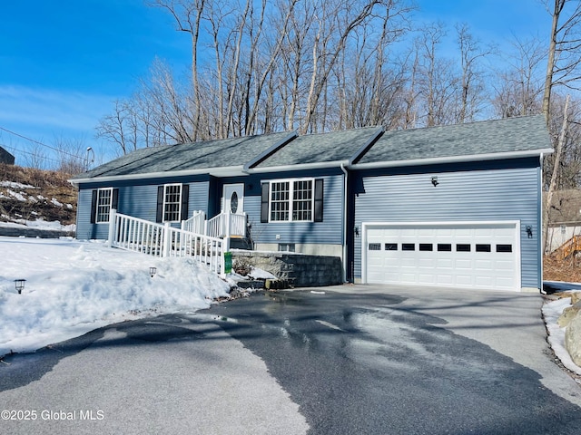 ranch-style house featuring a garage, roof with shingles, and driveway