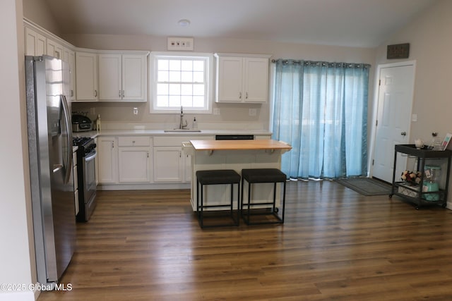 kitchen featuring lofted ceiling, stainless steel fridge with ice dispenser, a sink, range with gas cooktop, and butcher block counters