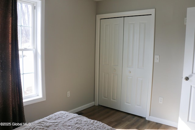 bedroom featuring a closet, baseboards, and dark wood-style floors