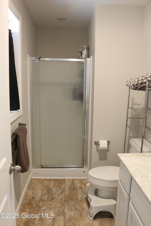 bathroom with vanity, toilet, and a shower stall