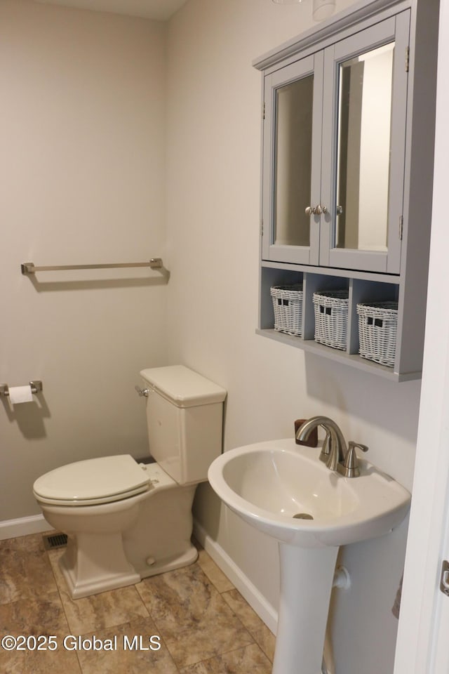 bathroom with toilet and baseboards