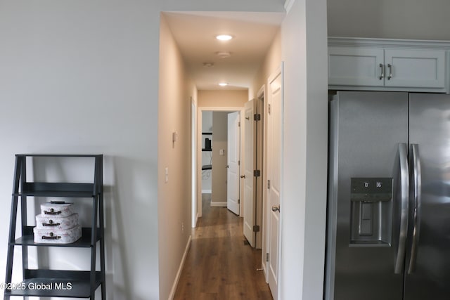 corridor with dark wood-style floors and baseboards