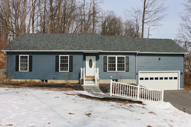 single story home with driveway, a shingled roof, and a garage