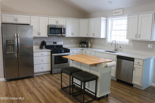 kitchen with dark wood-type flooring, butcher block countertops, stainless steel appliances, white cabinetry, and a sink