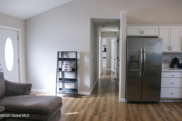 kitchen featuring baseboards, stainless steel fridge with ice dispenser, light countertops, wood finished floors, and white cabinetry