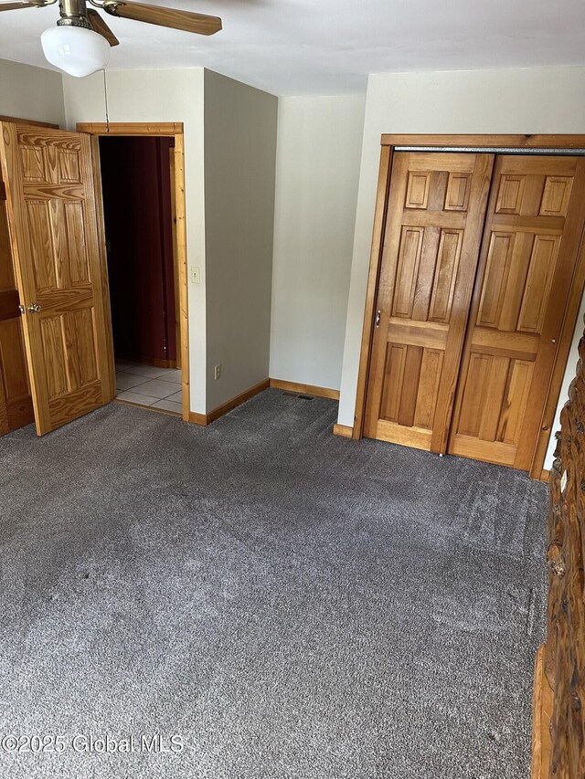 unfurnished bedroom with carpet floors, ceiling fan, baseboards, and a closet