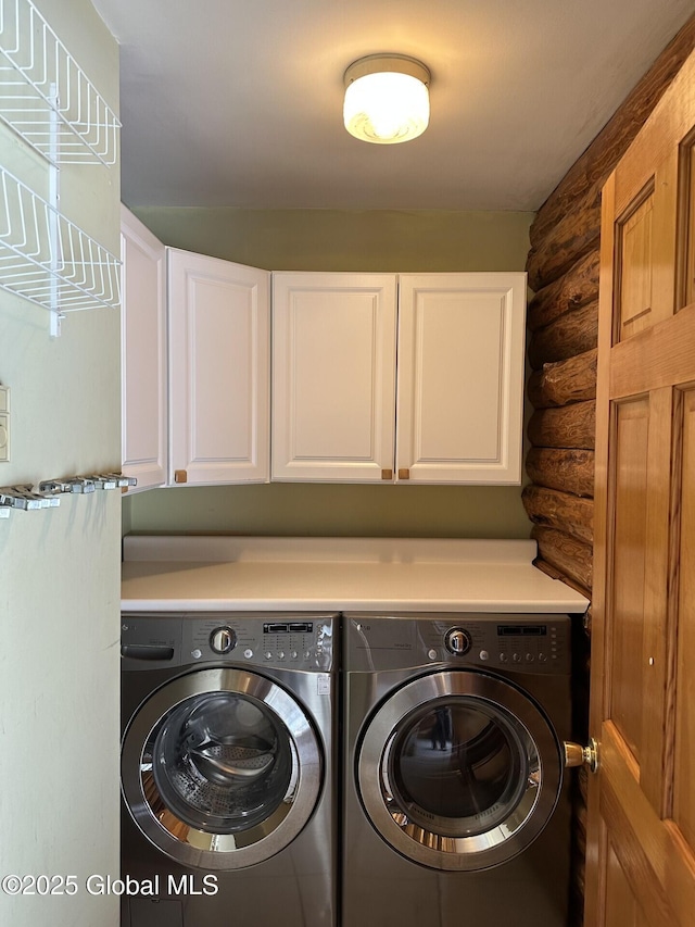 laundry area with rustic walls, cabinet space, and independent washer and dryer