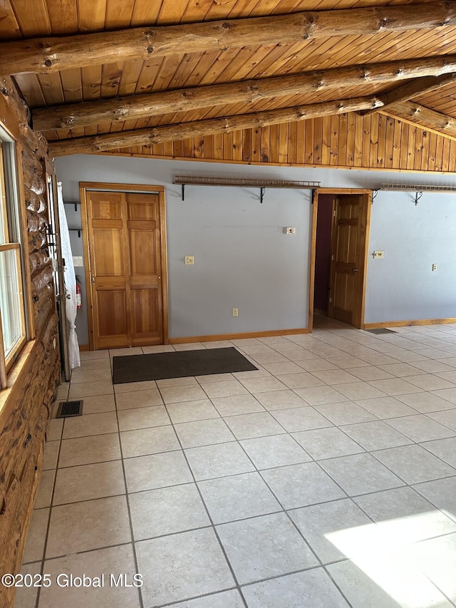 interior space with vaulted ceiling with beams, light tile patterned floors, visible vents, wood ceiling, and baseboards