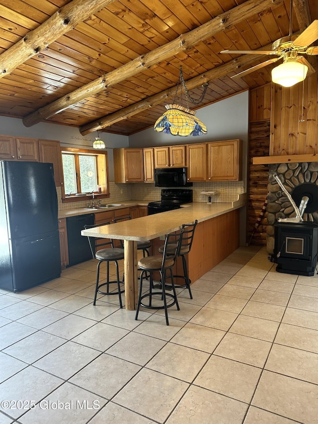 kitchen with a peninsula, black appliances, decorative backsplash, and light tile patterned flooring