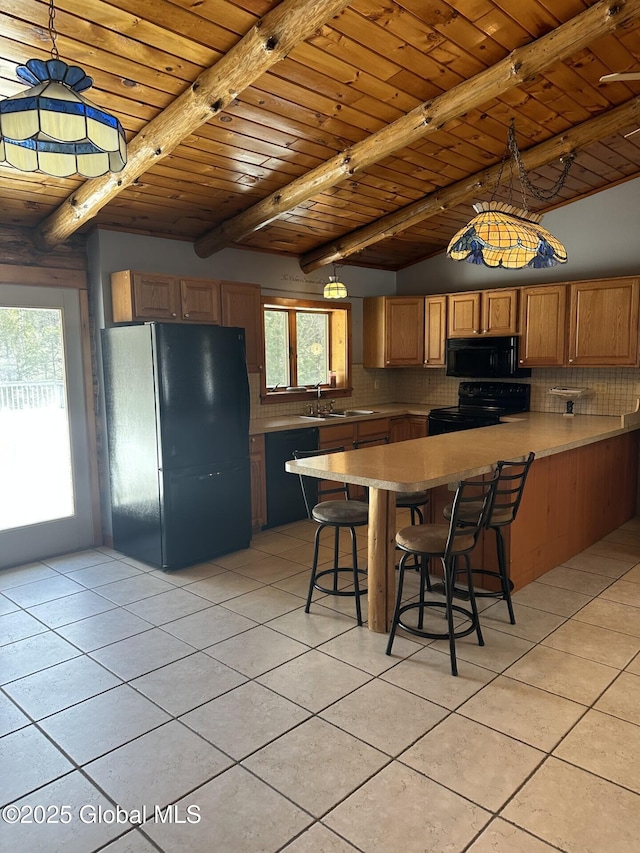 kitchen featuring a peninsula, black appliances, backsplash, and beamed ceiling