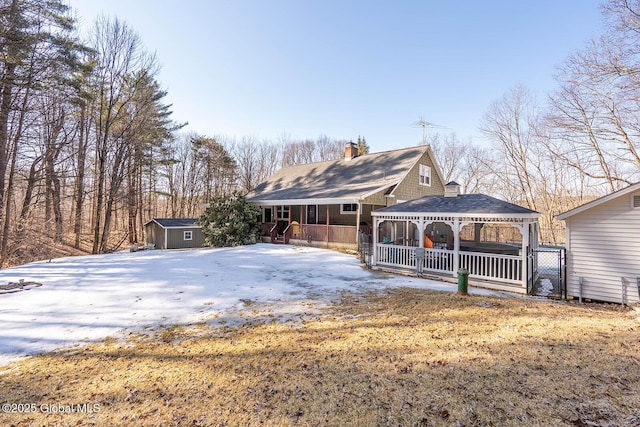 back of house with a gazebo, a shed, a chimney, and an outdoor structure