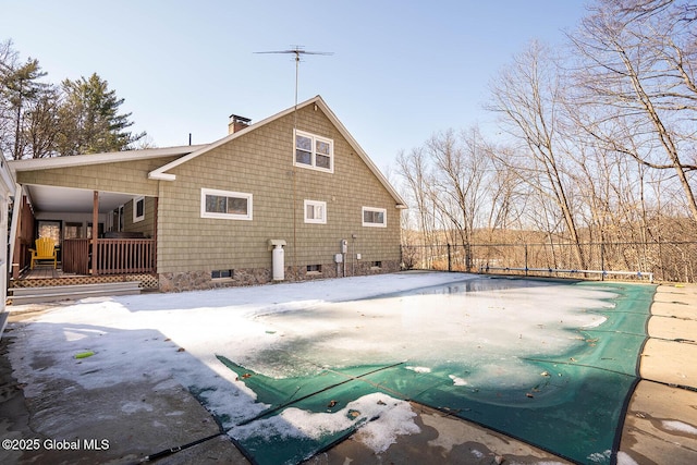 back of house with a fenced in pool, a chimney, and fence