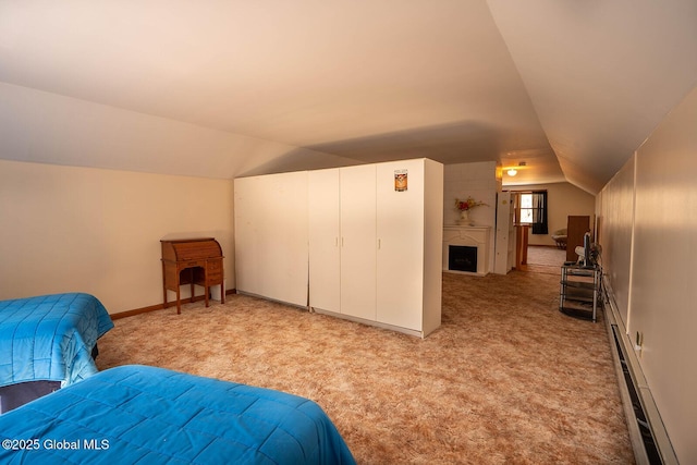 bedroom with baseboards, lofted ceiling, a fireplace, light carpet, and a baseboard heating unit