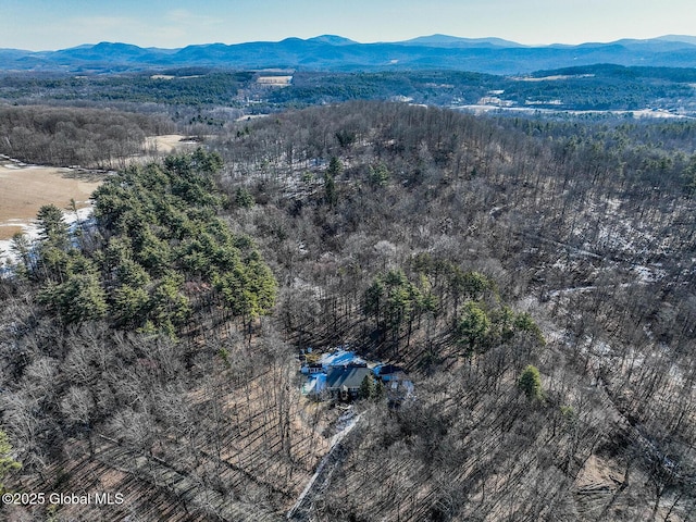 aerial view with a wooded view and a mountain view