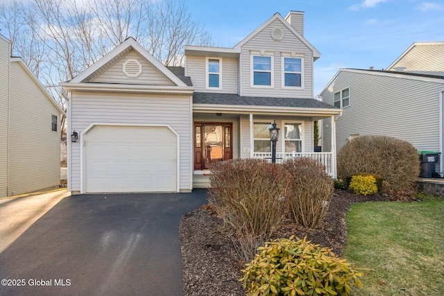 traditional-style home featuring a shingled roof, aphalt driveway, covered porch, a chimney, and an attached garage