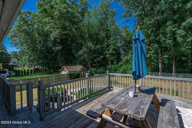 wooden terrace featuring outdoor dining space and a fenced backyard