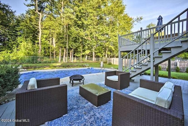 view of patio with a fenced in pool, an outdoor living space with a fire pit, a deck, a fenced backyard, and stairs