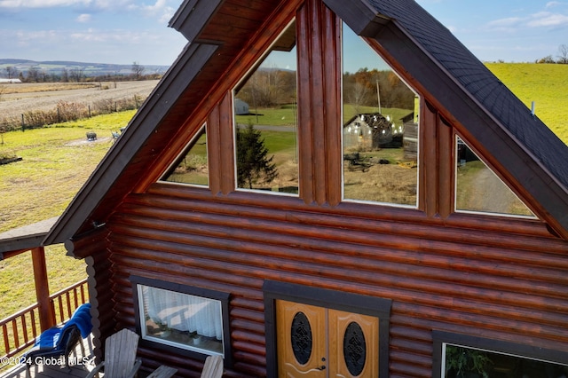 view of side of home with a rural view and log exterior