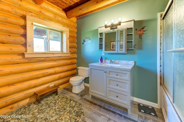 bathroom with vanity, baseboards, beam ceiling, toilet, and rustic walls