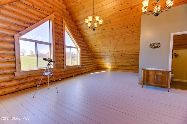 additional living space with lofted ceiling, a chandelier, and hardwood / wood-style flooring