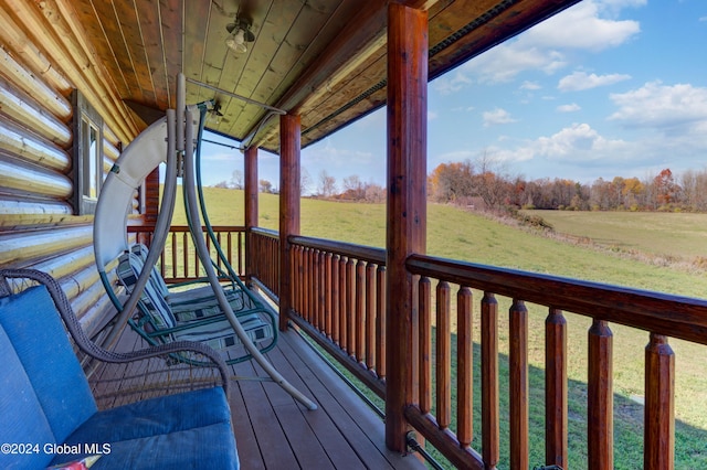 wooden deck with a lawn and a rural view