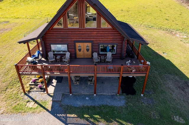 back of property featuring log siding, a wooden deck, and outdoor dining area