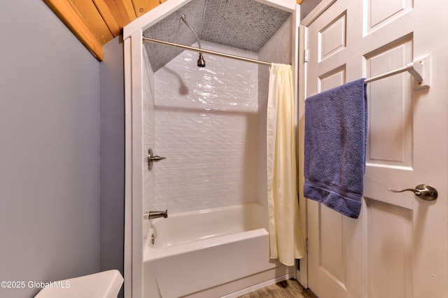 bathroom featuring toilet and shower / tub combo with curtain