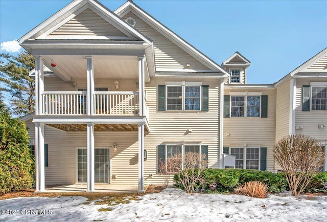 rear view of house featuring a porch and a balcony