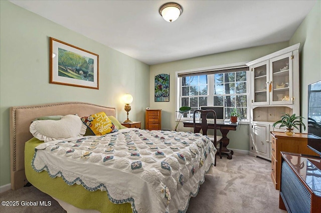 bedroom with baseboards and light carpet