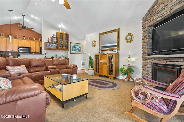 living area featuring a stone fireplace, lofted ceiling, a ceiling fan, and carpet floors