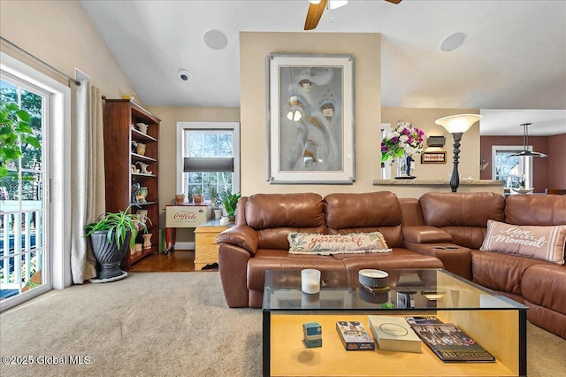 living area with a ceiling fan, vaulted ceiling, and carpet