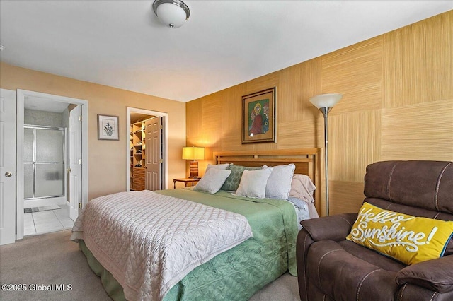 bedroom with tile patterned flooring, carpet flooring, a closet, and ensuite bathroom