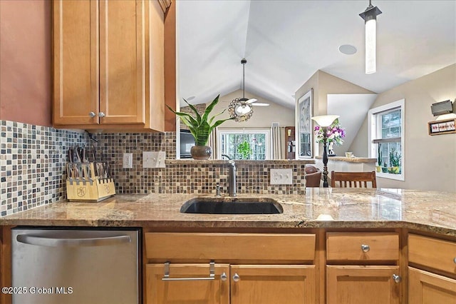 kitchen featuring a sink, backsplash, stainless steel dishwasher, and vaulted ceiling