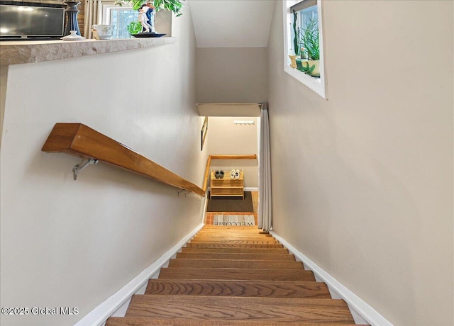 stairs with wood finished floors and baseboards