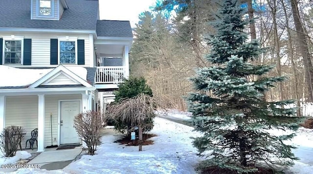 exterior space with a porch and a shingled roof