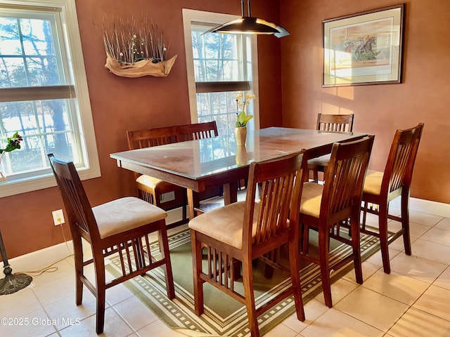 dining space with plenty of natural light, baseboards, and light tile patterned floors