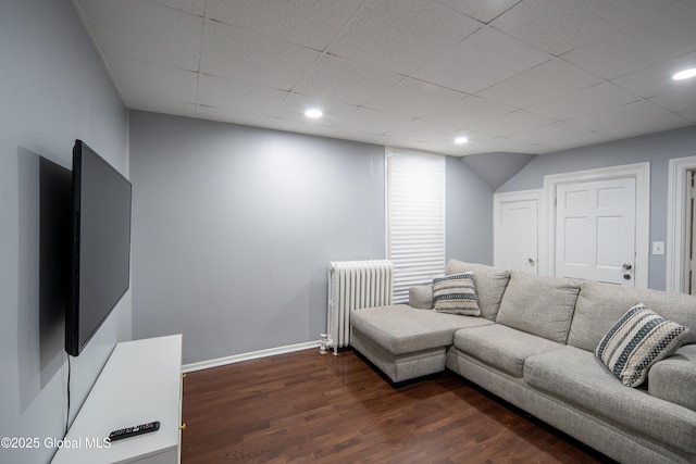 living area featuring radiator, baseboards, dark wood finished floors, recessed lighting, and a paneled ceiling