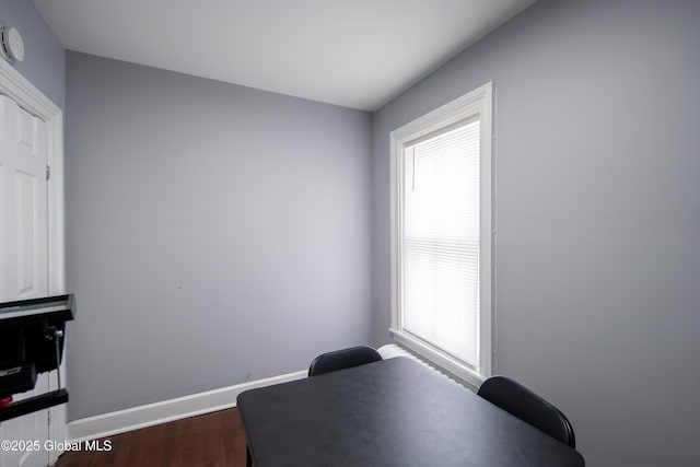 living area with baseboards and dark wood-style flooring