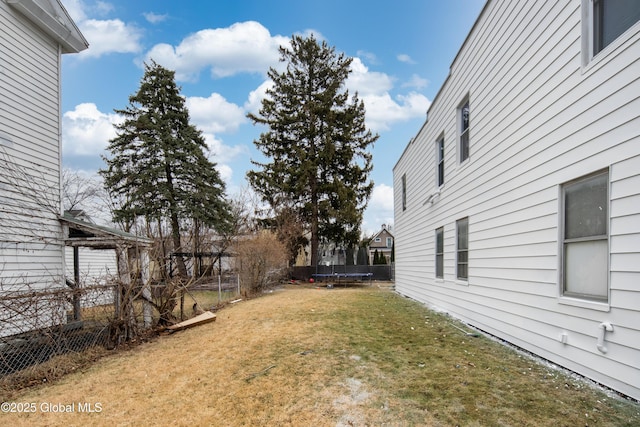 view of yard with a trampoline and a fenced backyard