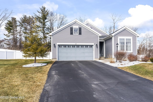 view of front of home featuring aphalt driveway, a garage, a front lawn, and fence