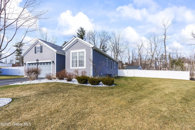 view of side of property featuring aphalt driveway, fence, a garage, and a lawn