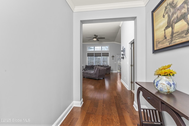 hall featuring baseboards, wood finished floors, and crown molding