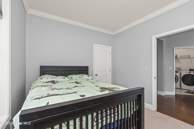 carpeted bedroom with washer and clothes dryer, baseboards, and ornamental molding