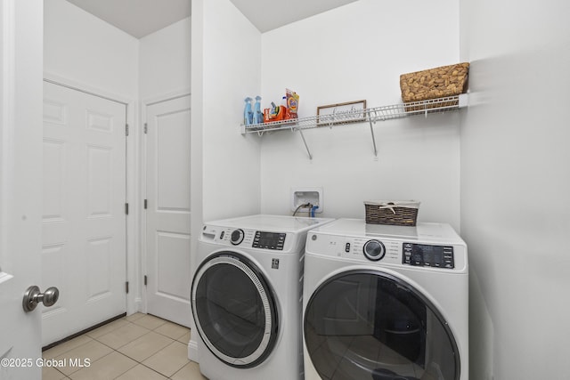 laundry room featuring light tile patterned floors, laundry area, and separate washer and dryer