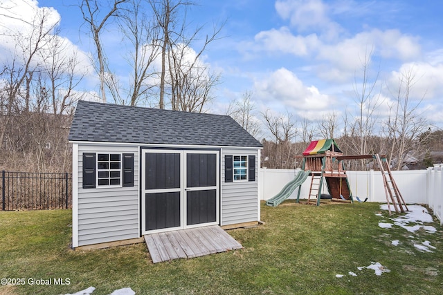 view of shed featuring a playground and a fenced backyard