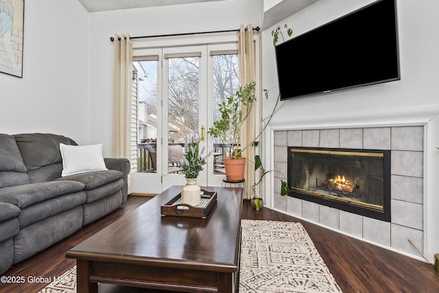 living area with wood finished floors and a tiled fireplace